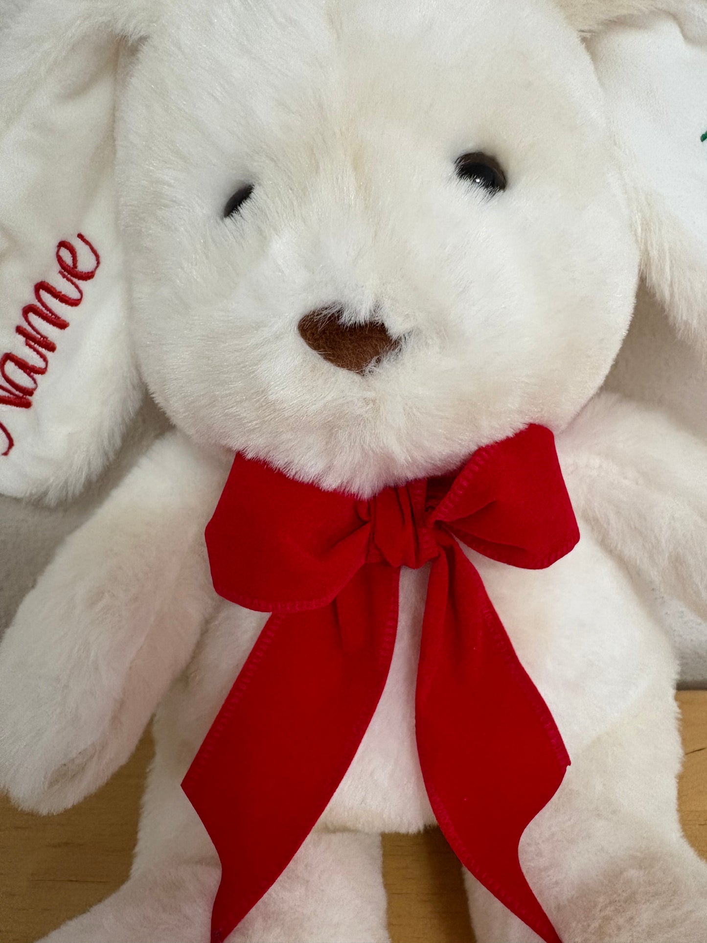White teddy bear with a red bow on a white background