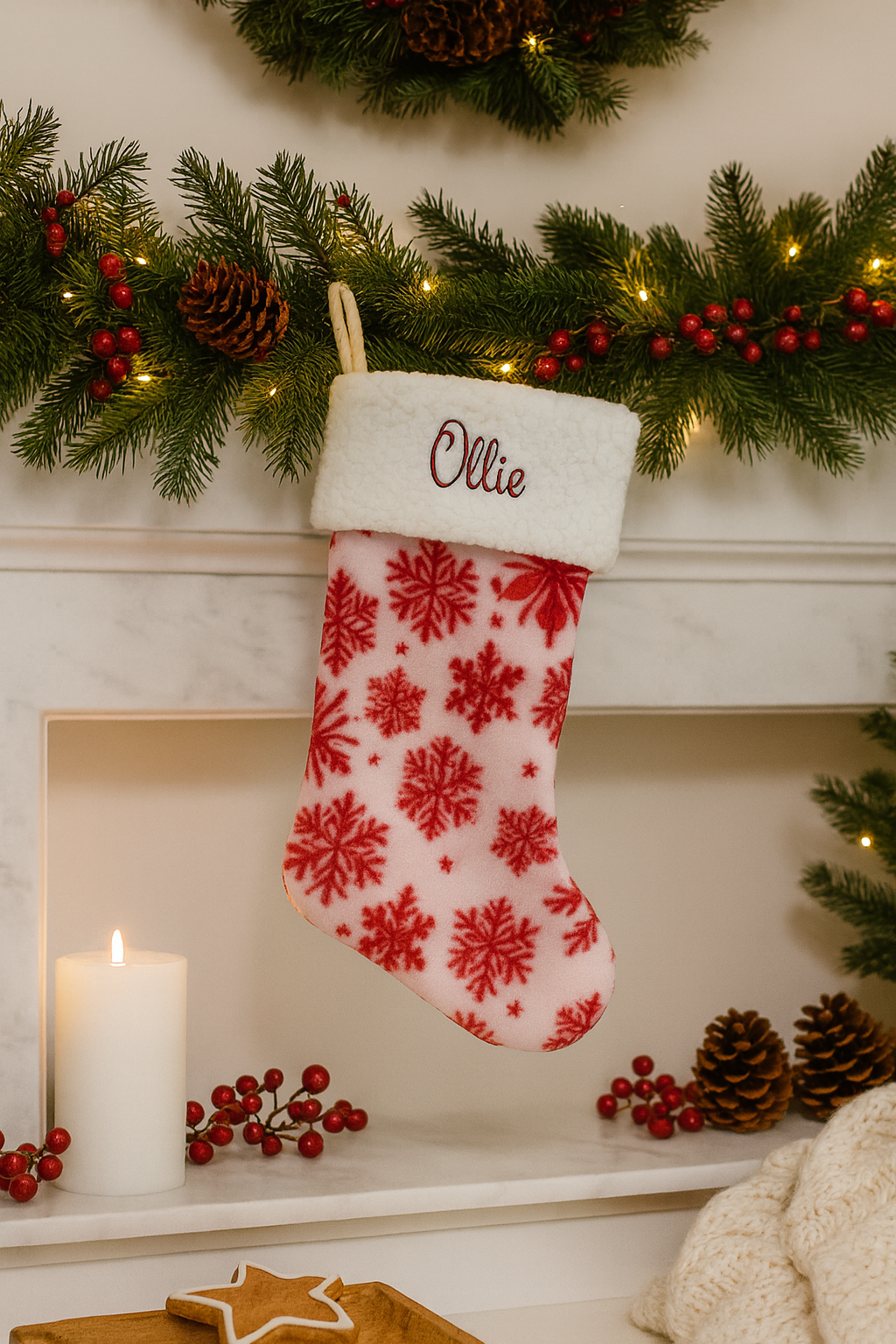 Personalized Christmas stocking with red snowflake pattern on a decorated fireplace mantel.
